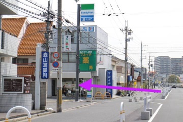 左折してファミリーマートと薬局の看板の間の細い路地に進入します。